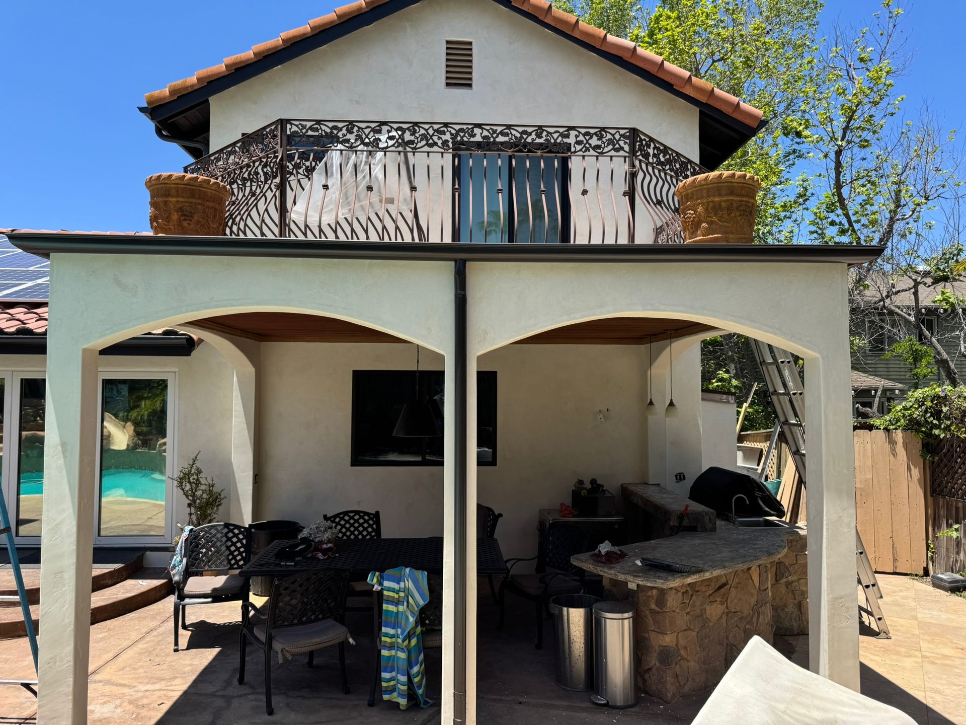 A white house with a covered patio area with a table and chairs
