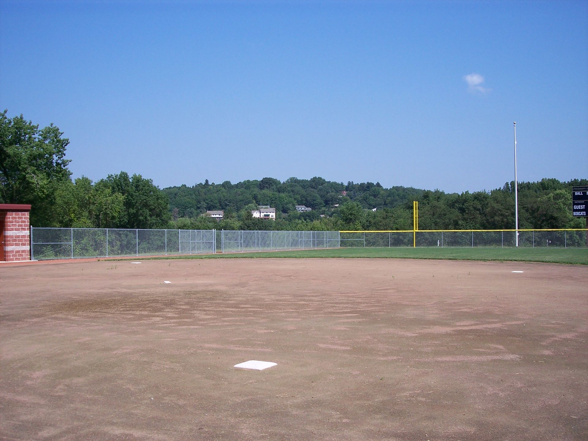 An empty baseball field with a scoreboard in the background