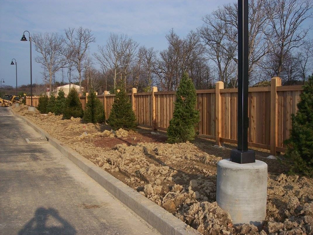 A street with a wooden fence and trees on the side of it