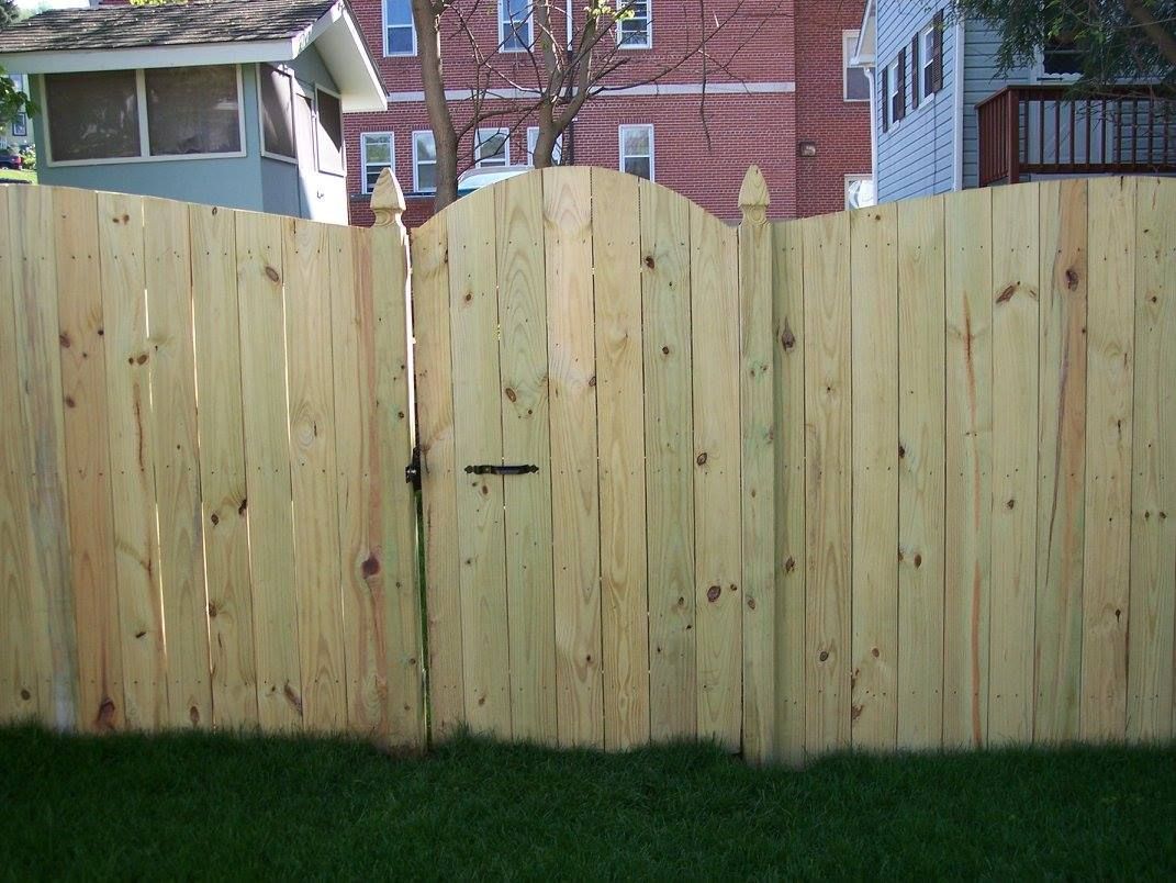 A wooden fence with a gate in the middle of it