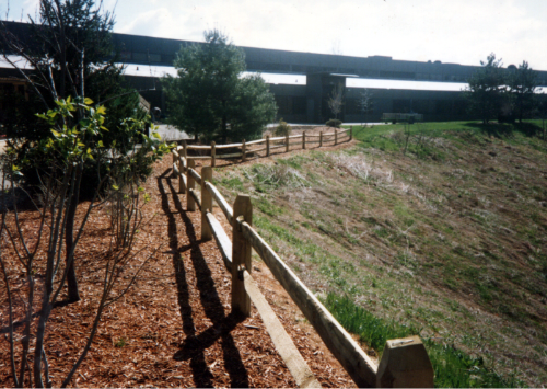 A wooden fence with a bridge in the background
