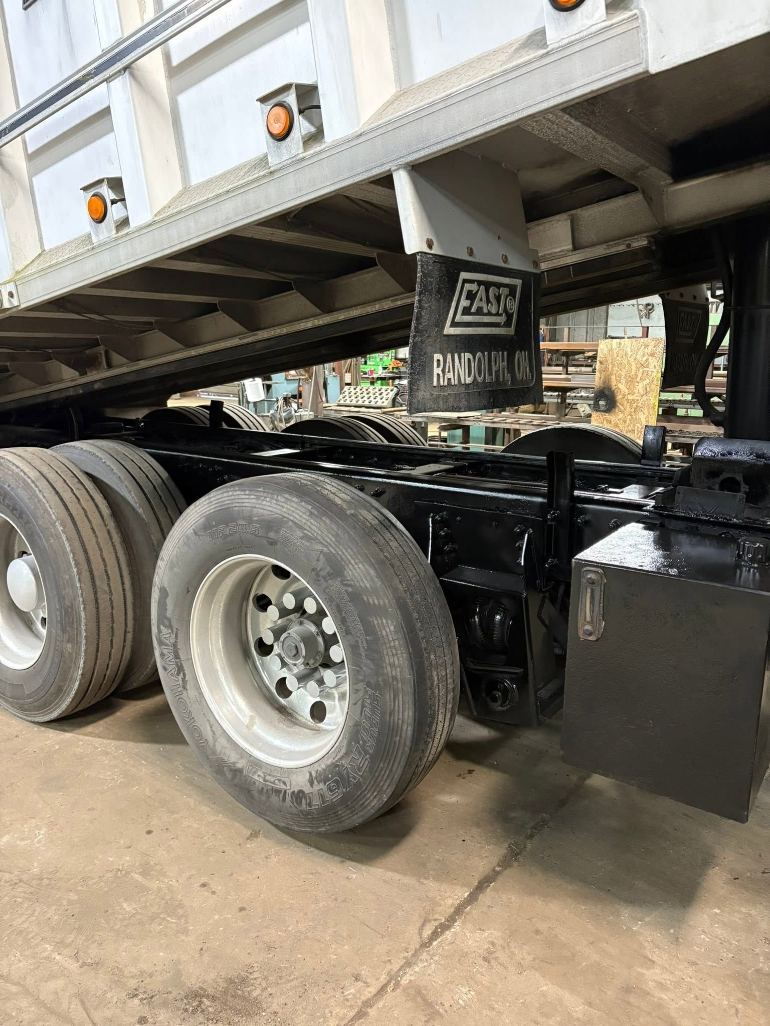 Close-up of a black semi-truck chassis with dual rear tires and a raised trailer bed.