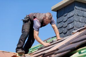 roofer next to the chimney verifying the tiles