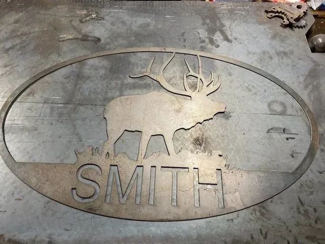 Custom oval metal sign featuring a silhouette of an elk above the name 