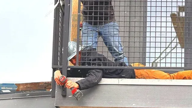 Two construction workers in high-visibility gear install a metal railing on a building exterior.