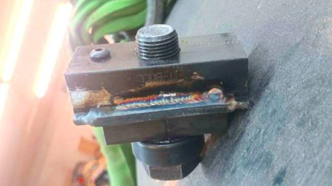 Black metal tool holder with a bolt, weld marks, and a set screw.