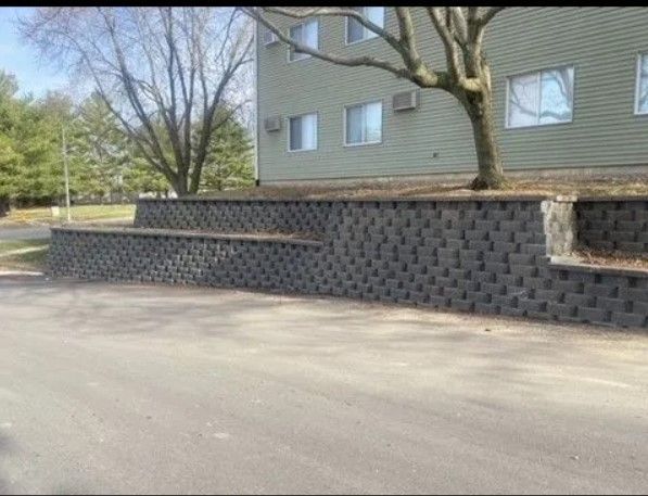 A brick wall with a bench in front of a building.