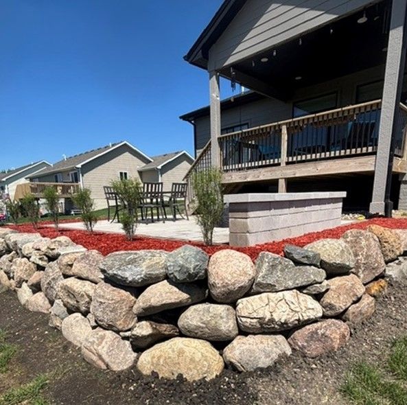 A house with a stone wall in front of it.
