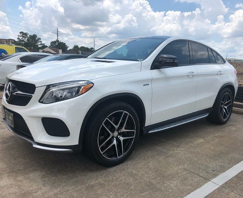 A white mercedes benz gle is parked in a parking lot.