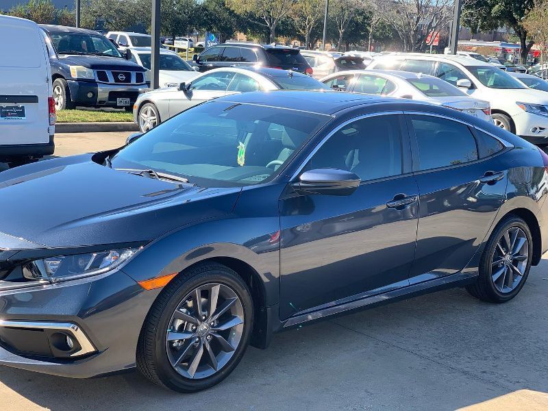 A black honda civic is parked in a parking lot.