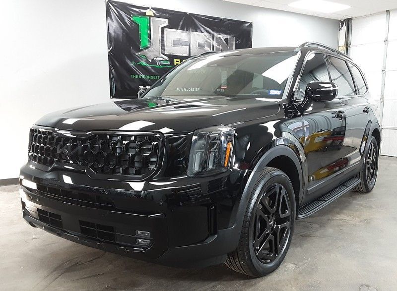 A black suv is parked in a garage in front of a sign.