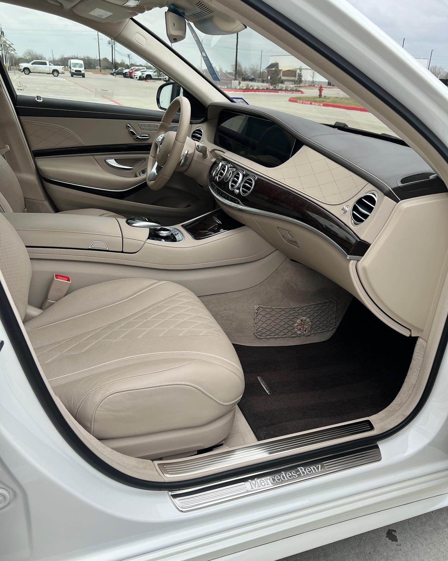 The interior of a white mercedes benz s class is shown with the door open.