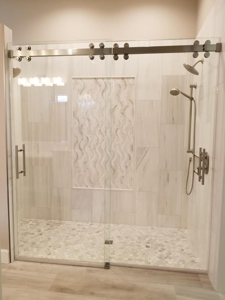 A shower with a sliding glass door and a shower head.