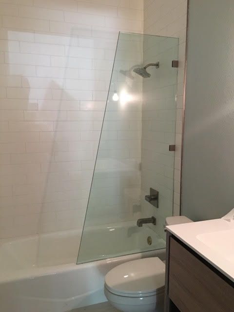 Frameless shower enclosure