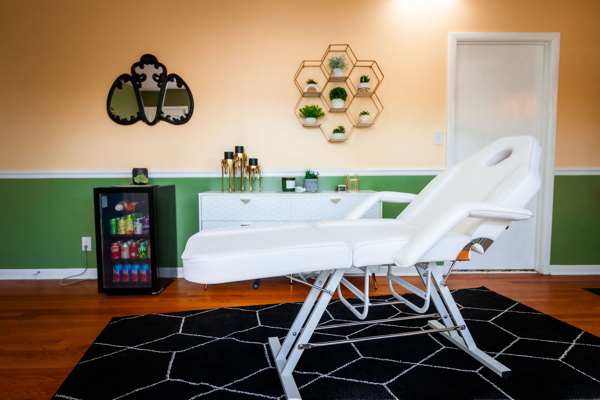 A white massage table in a room with a black rug