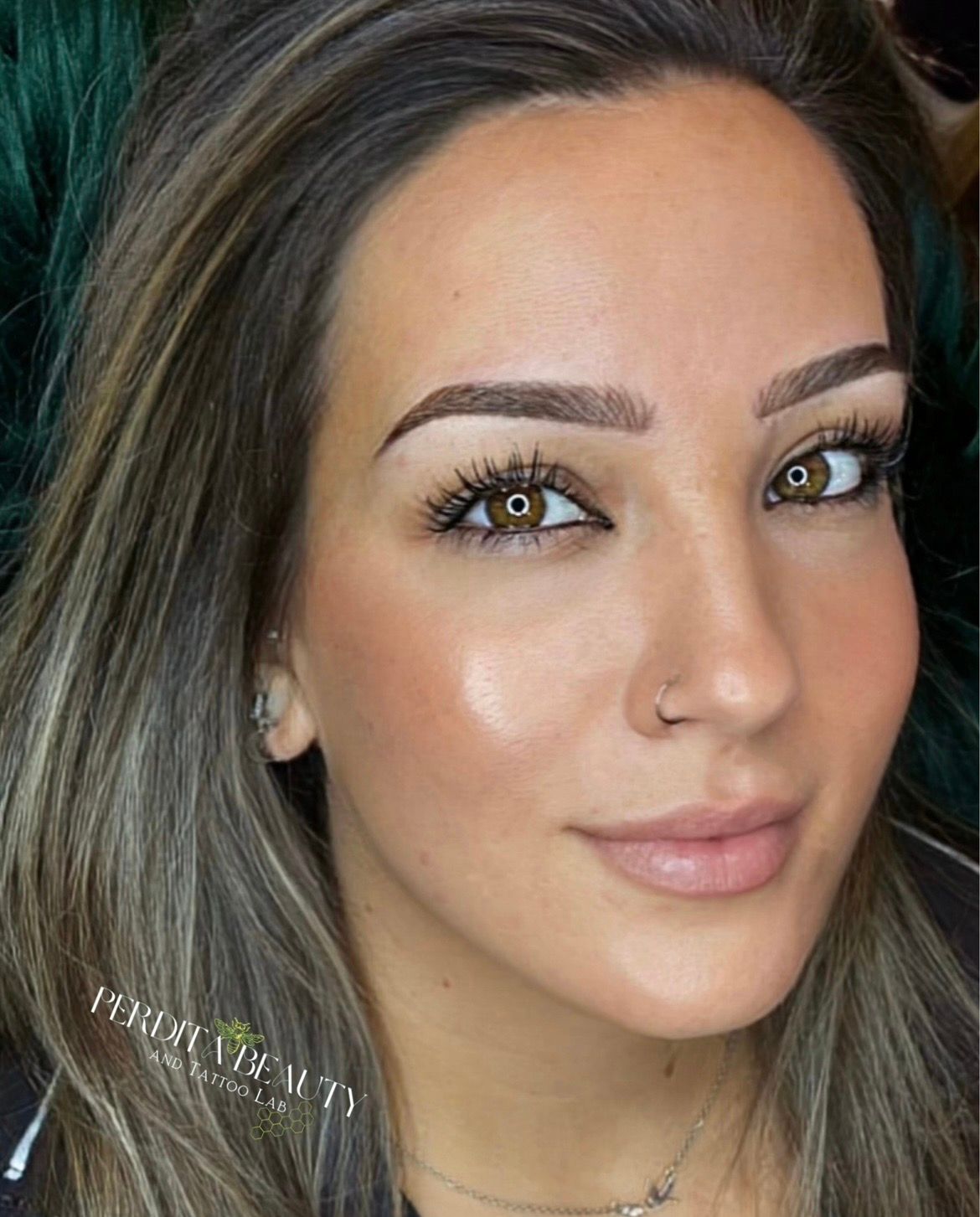 Close-up portrait of a woman with highlighted hair, neutral expression, and a nose ring