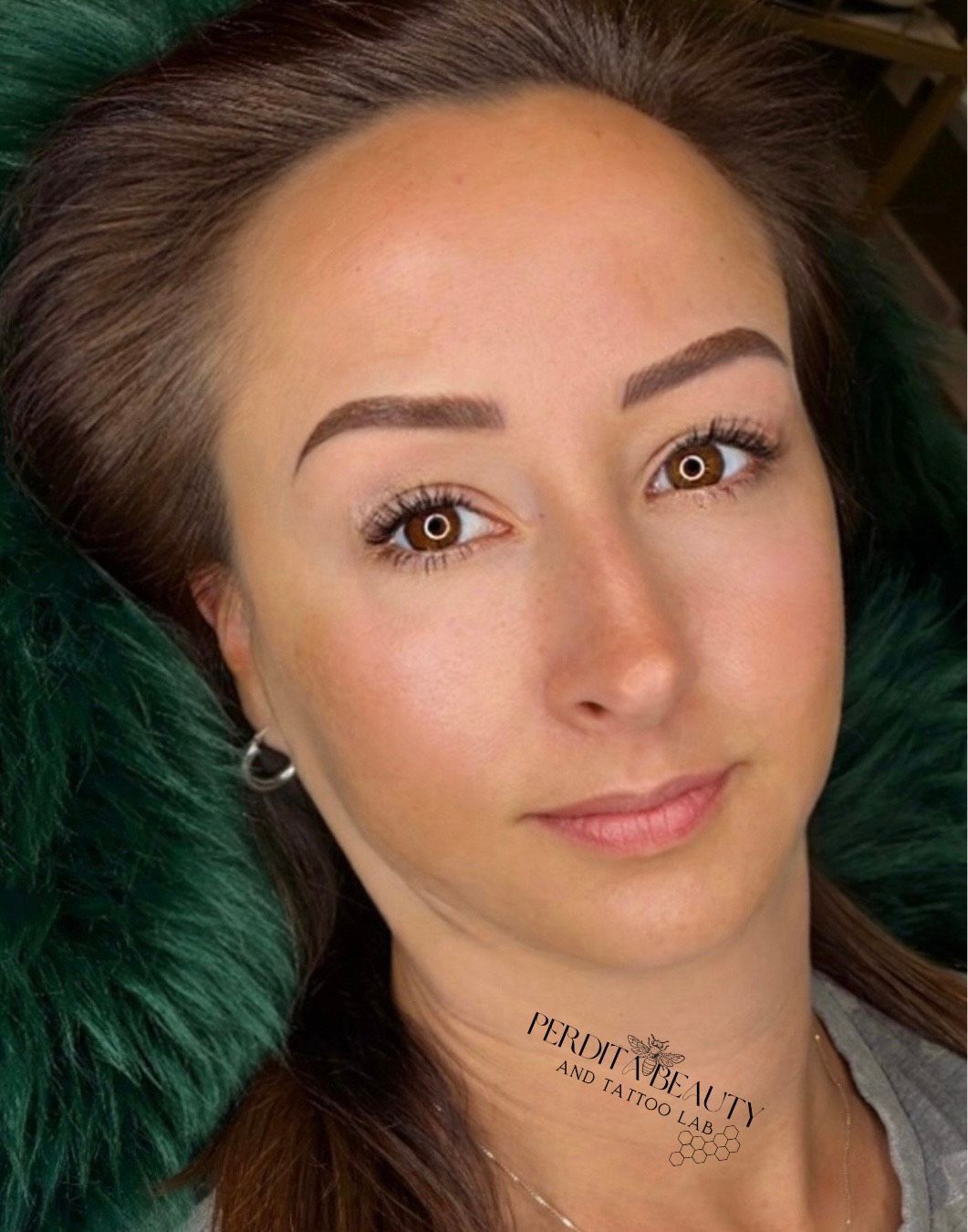 A close-up of a woman's face with a tattoo on her neck.