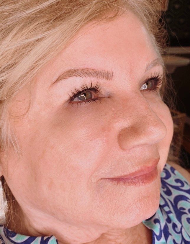 A close up of a woman 's face with long eyelashes.