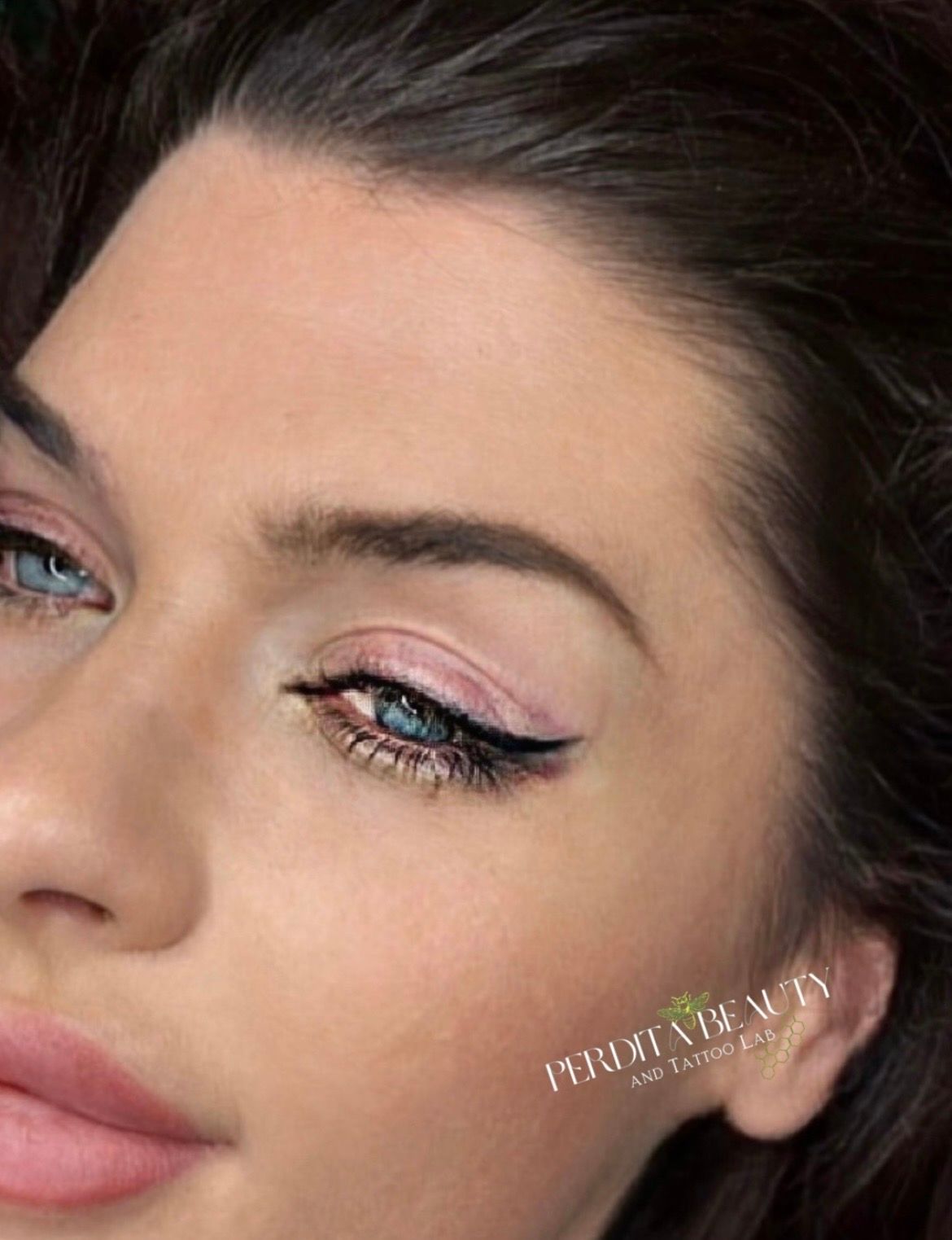 Woman with blue eyes, pink eyeshadow, and black eyeliner.