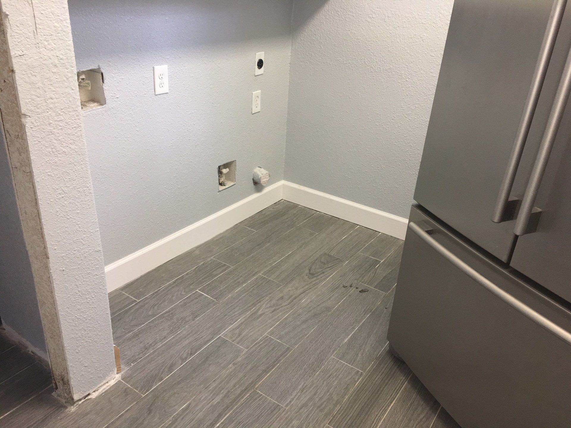 A laundry room with a refrigerator and a washer and dryer.