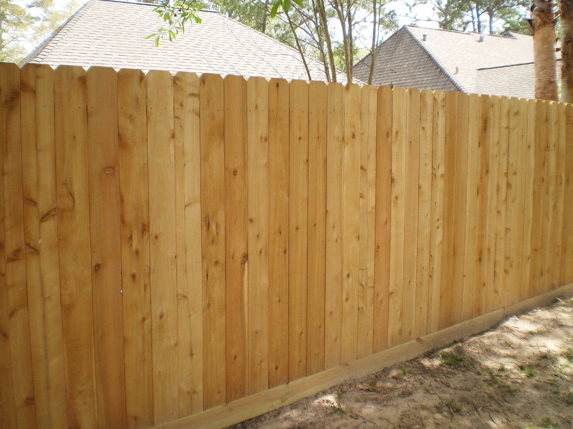 A wooden fence is sitting in front of a house.
