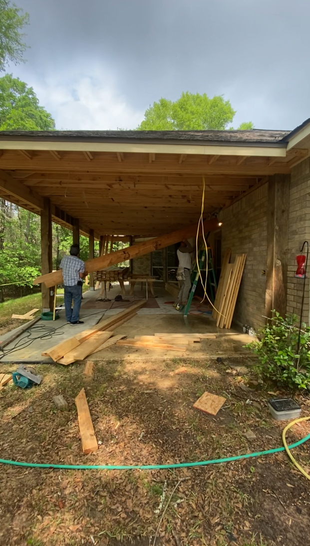 A man is standing in front of a house under construction.