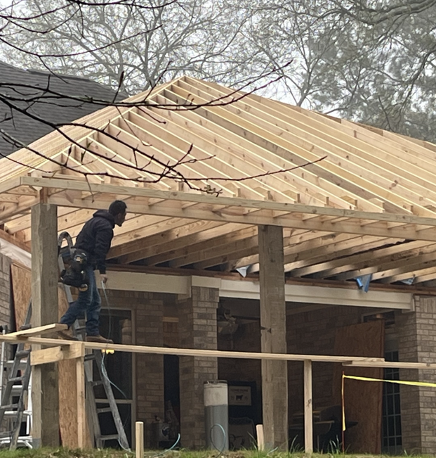 A man is working on the roof of a house.