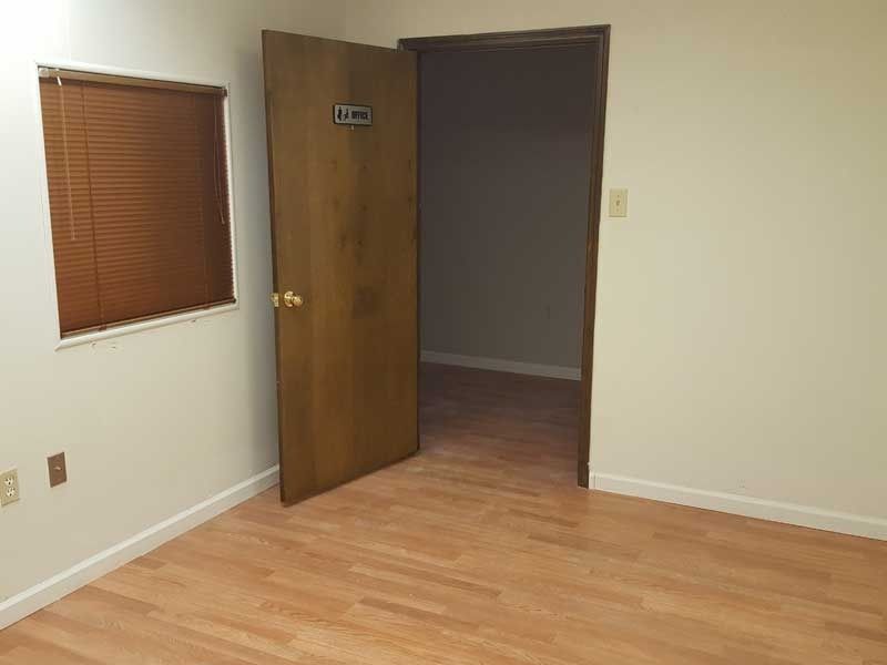 An empty room with hardwood floors and a door that is open.