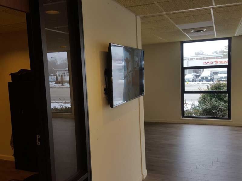A flat screen tv is mounted on a wall in a hallway