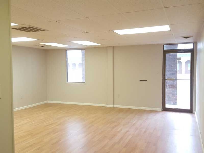 An empty room with hardwood floors and a door