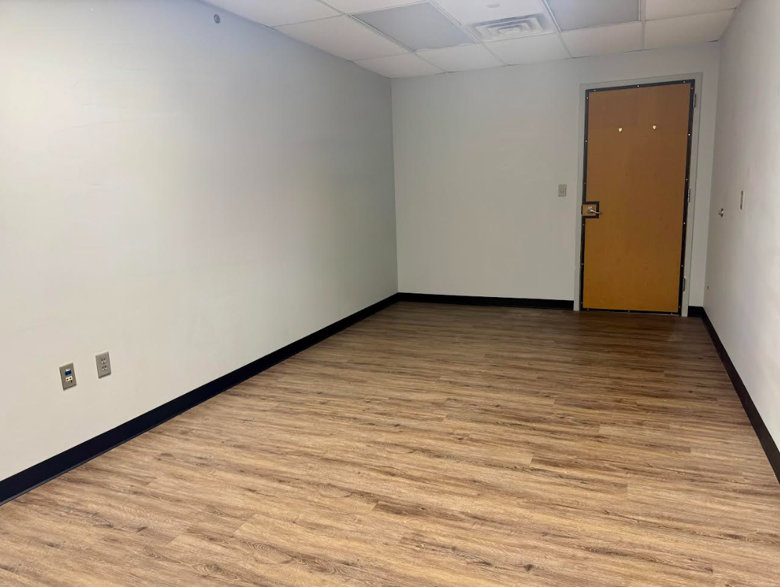 An empty room with wooden floors and a door