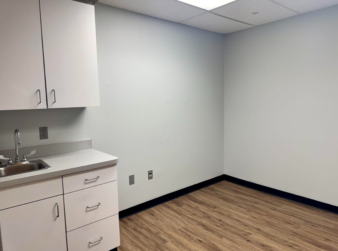 An empty room with a sink and cabinets in it