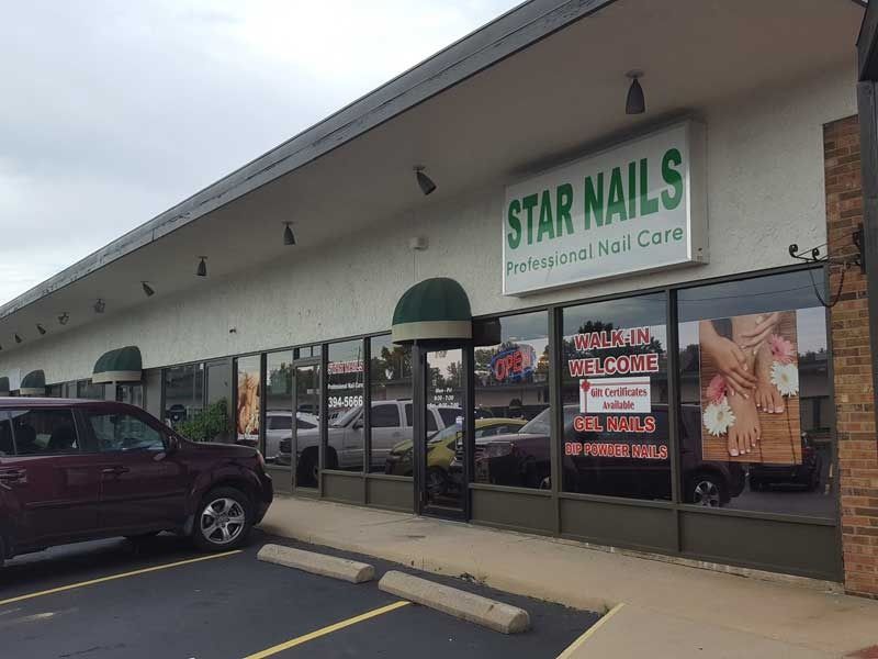A car is parked in front of a nail salon called star nails.