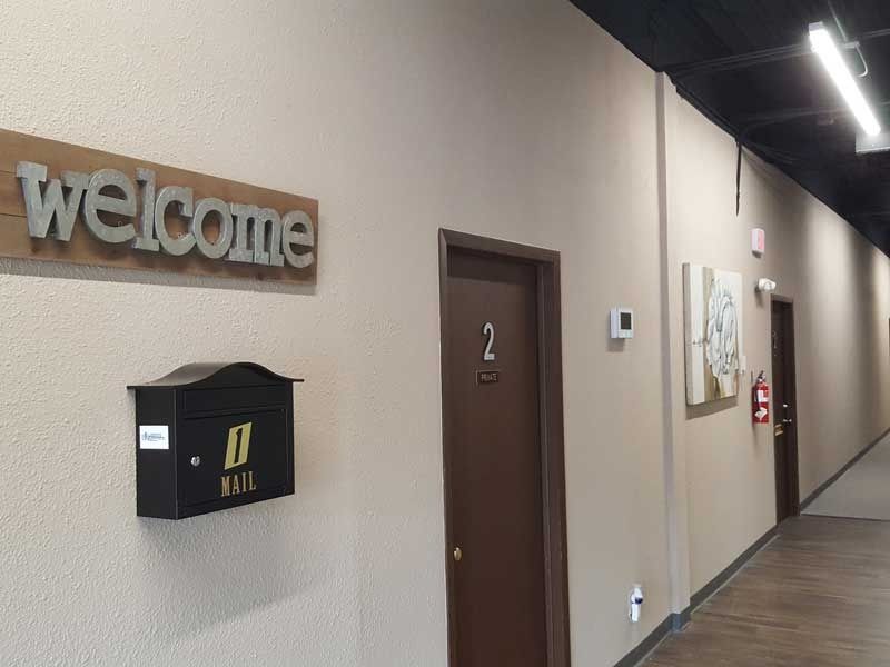 A hallway with a welcome sign and a mailbox