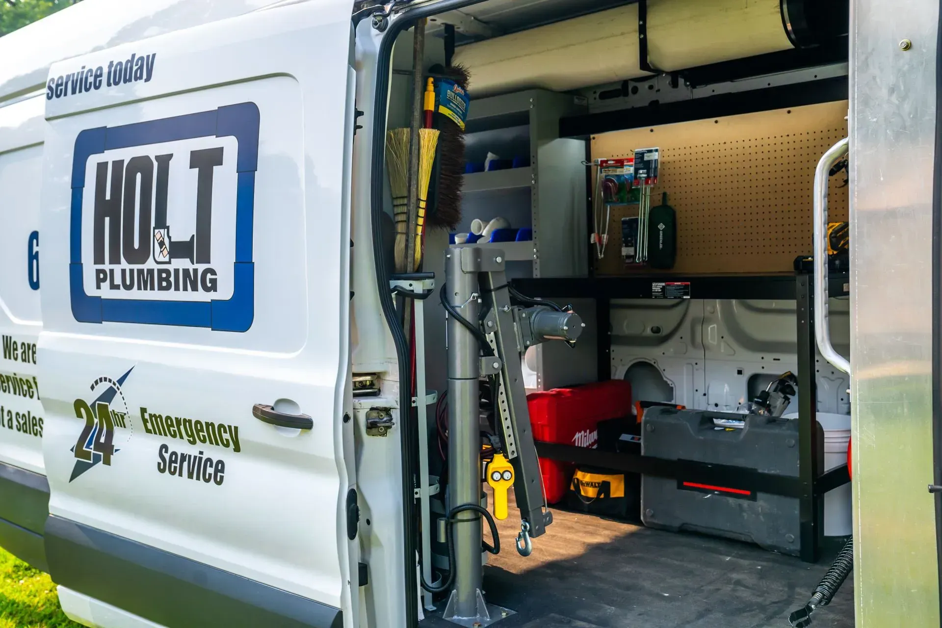 Holt Plumbing service van with open door, showing tools and storage.