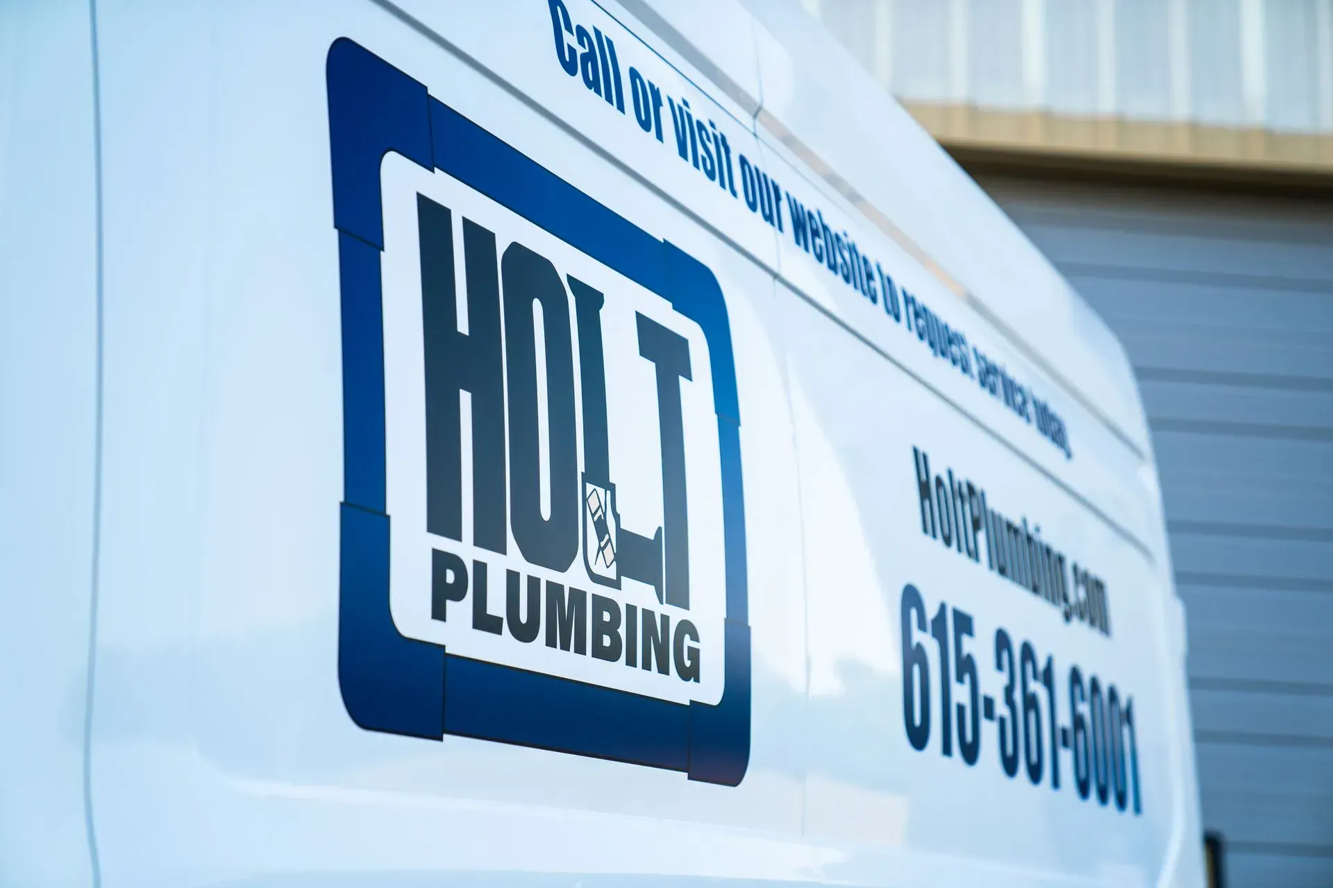 White van with Holt Plumbing logo and contact information.