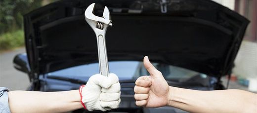 Satisfied client and mechanic holding a wrench