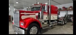Red and cream semi-truck parked inside a garage.