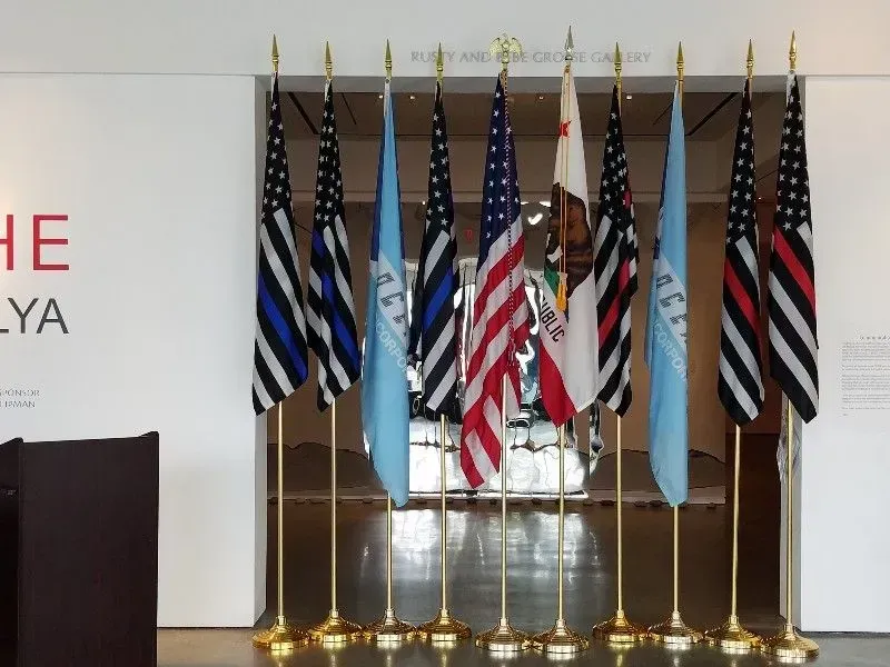 Flags displayed indoors: US, California, thin blue/red lines, and light blue flags.