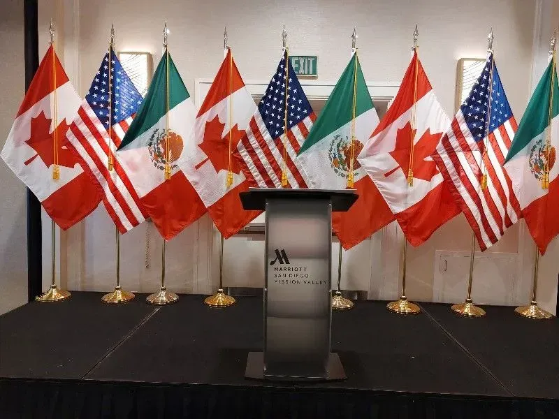 Flags of Canada, United States, and Mexico on stage with a podium.