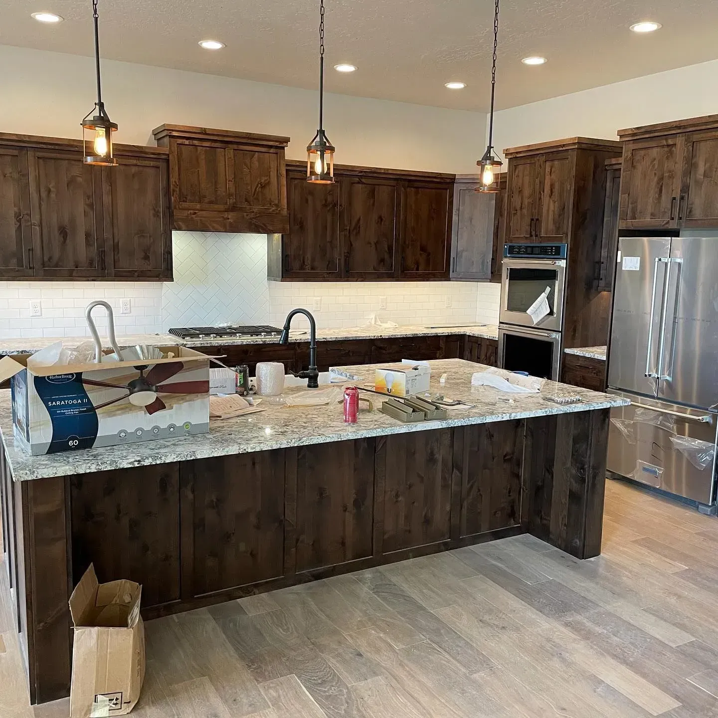 Kitchen with dark wood cabinets, a granite island, and stainless steel appliances.