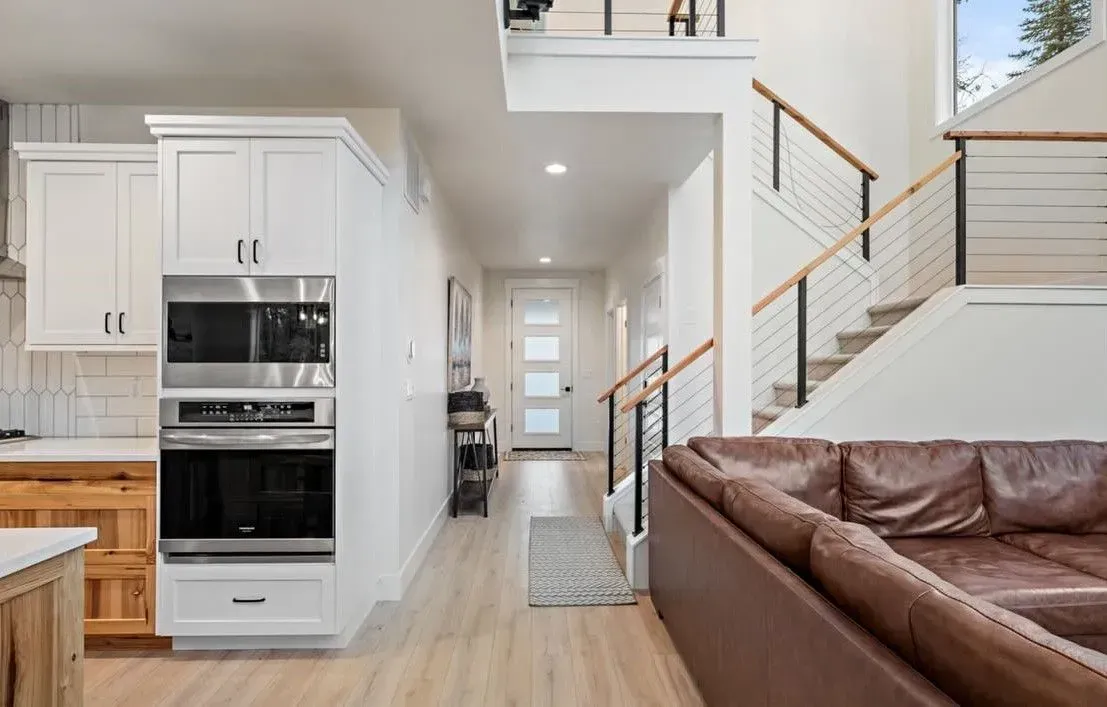 Interior view of a modern home with a hallway, stairs, and kitchen area.