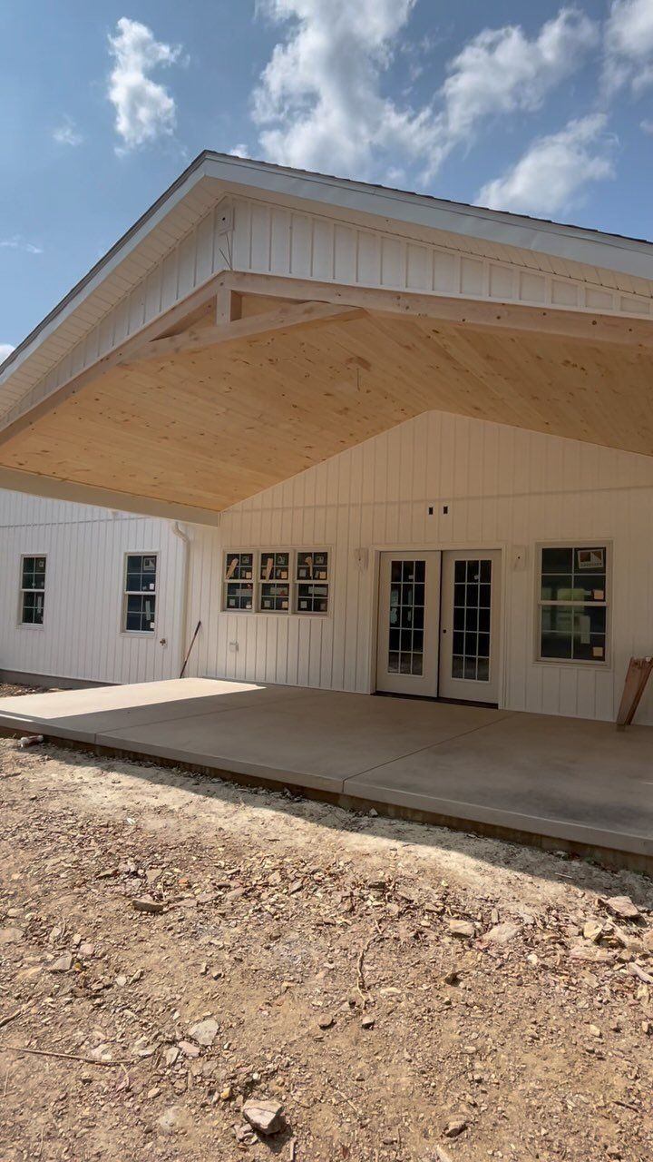 A white house with a wooden roof is being built.