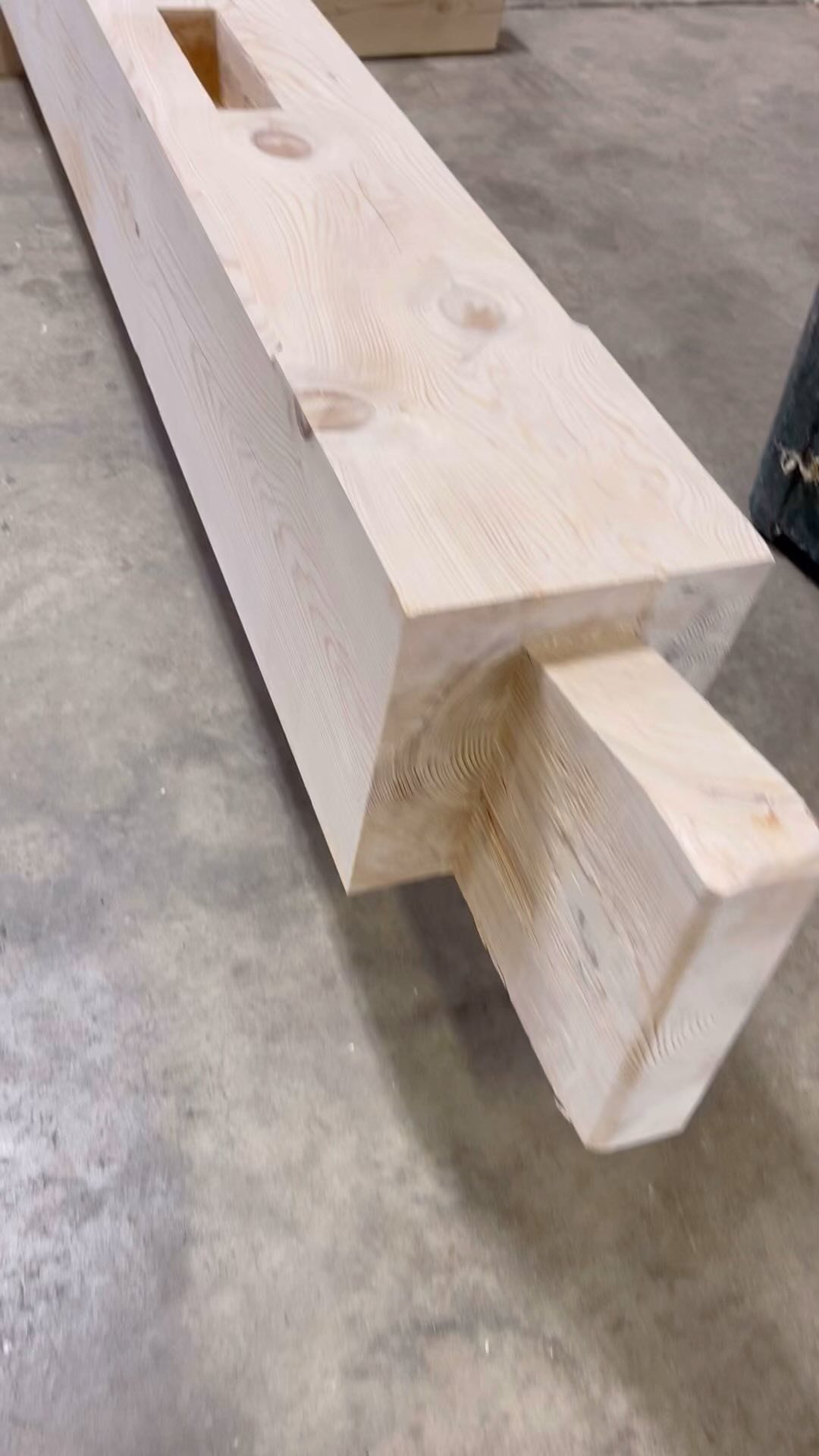A large piece of wood is sitting on a concrete floor.