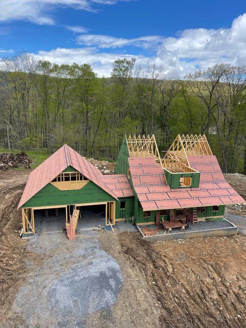 An aerial view of a house under construction in the middle of a dirt field.