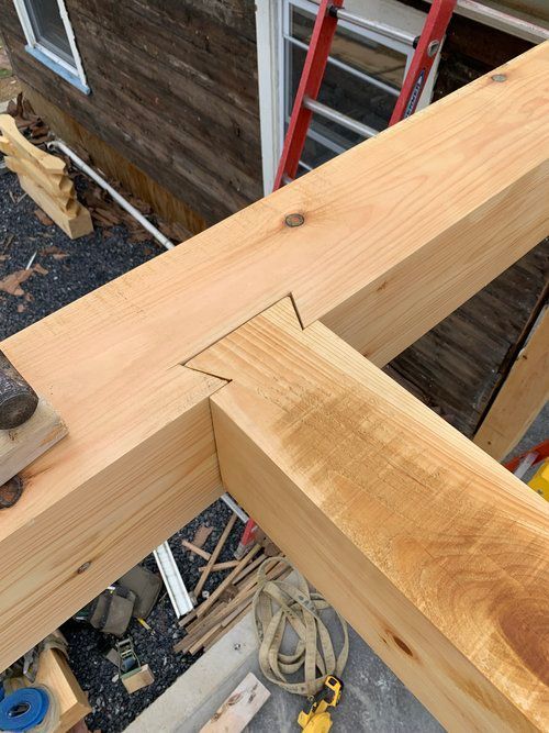 A wooden beam is being built with a ladder in the background.