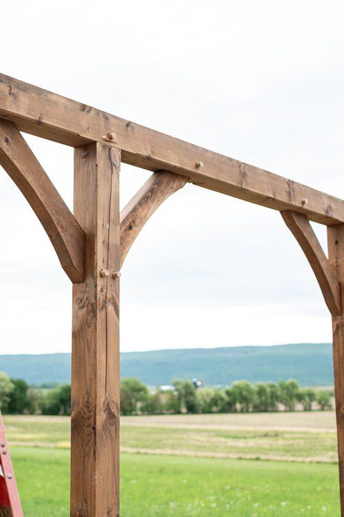 A wooden structure is being built in a grassy field.