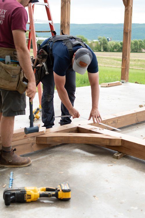Two men are working on a wooden structure in a garage.