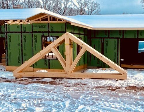 A house is being built with green walls and a wooden trusses