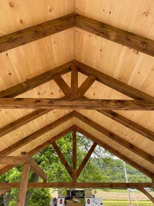 The inside of a wooden structure with a vaulted ceiling and wooden beams.